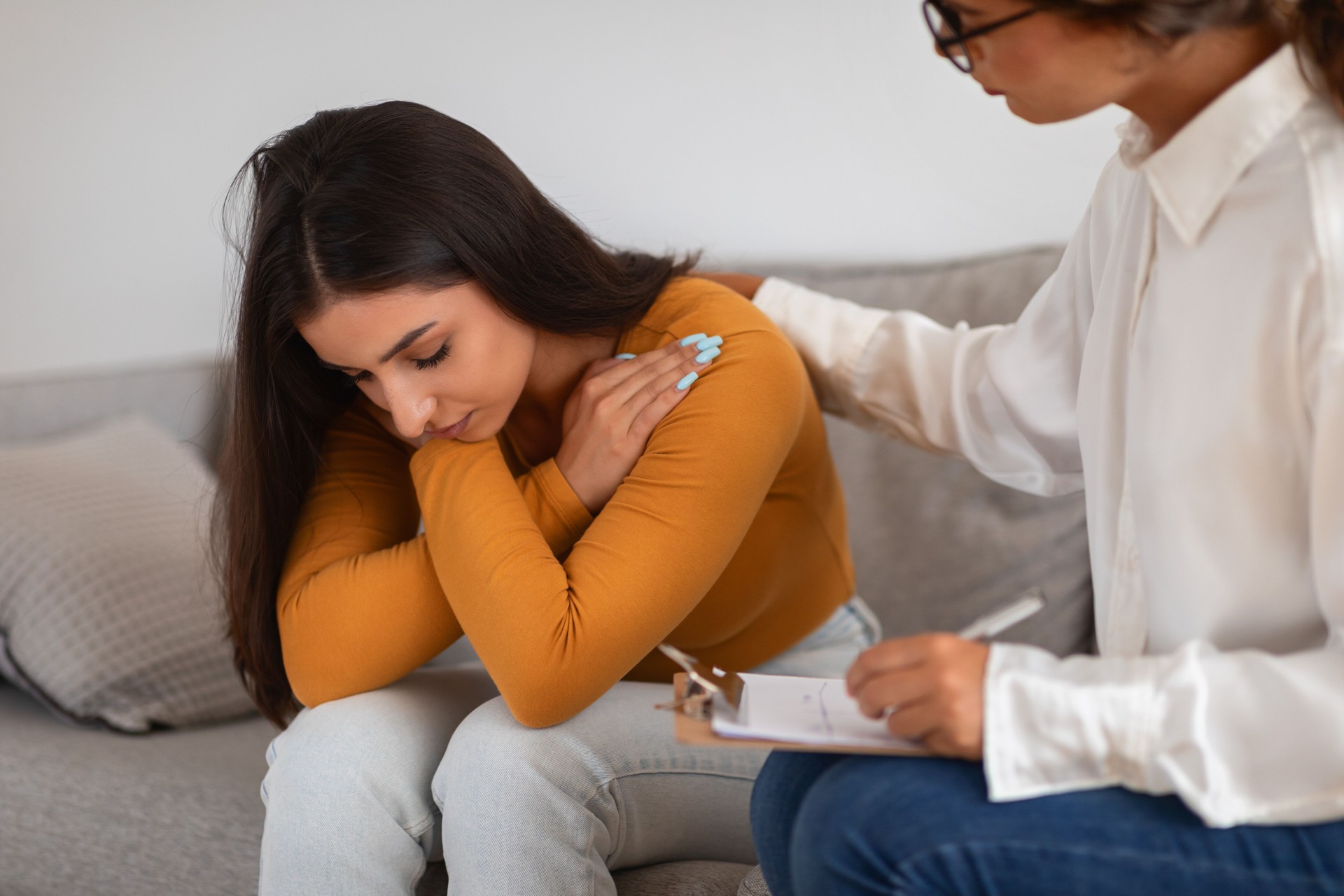 Woman receiving consolation from a lady therapist